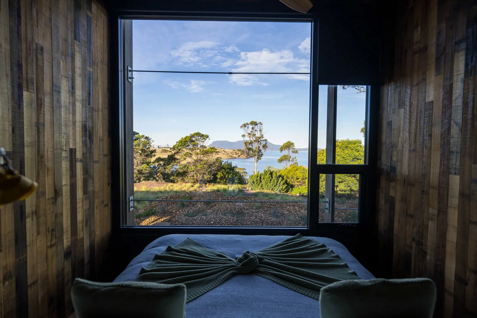 Shot of the bedroom interior at Spring Bay Mill. Showcasing the incredible views that can be seen from bed.