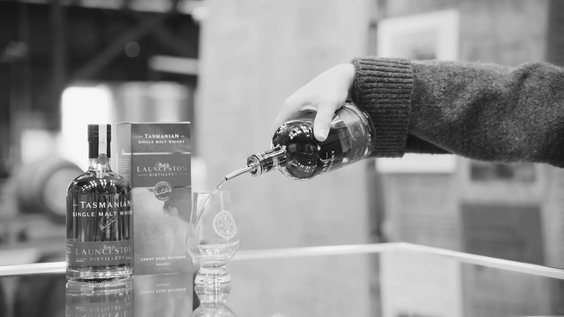Pouring whisky from a bottle into a specialised glass.