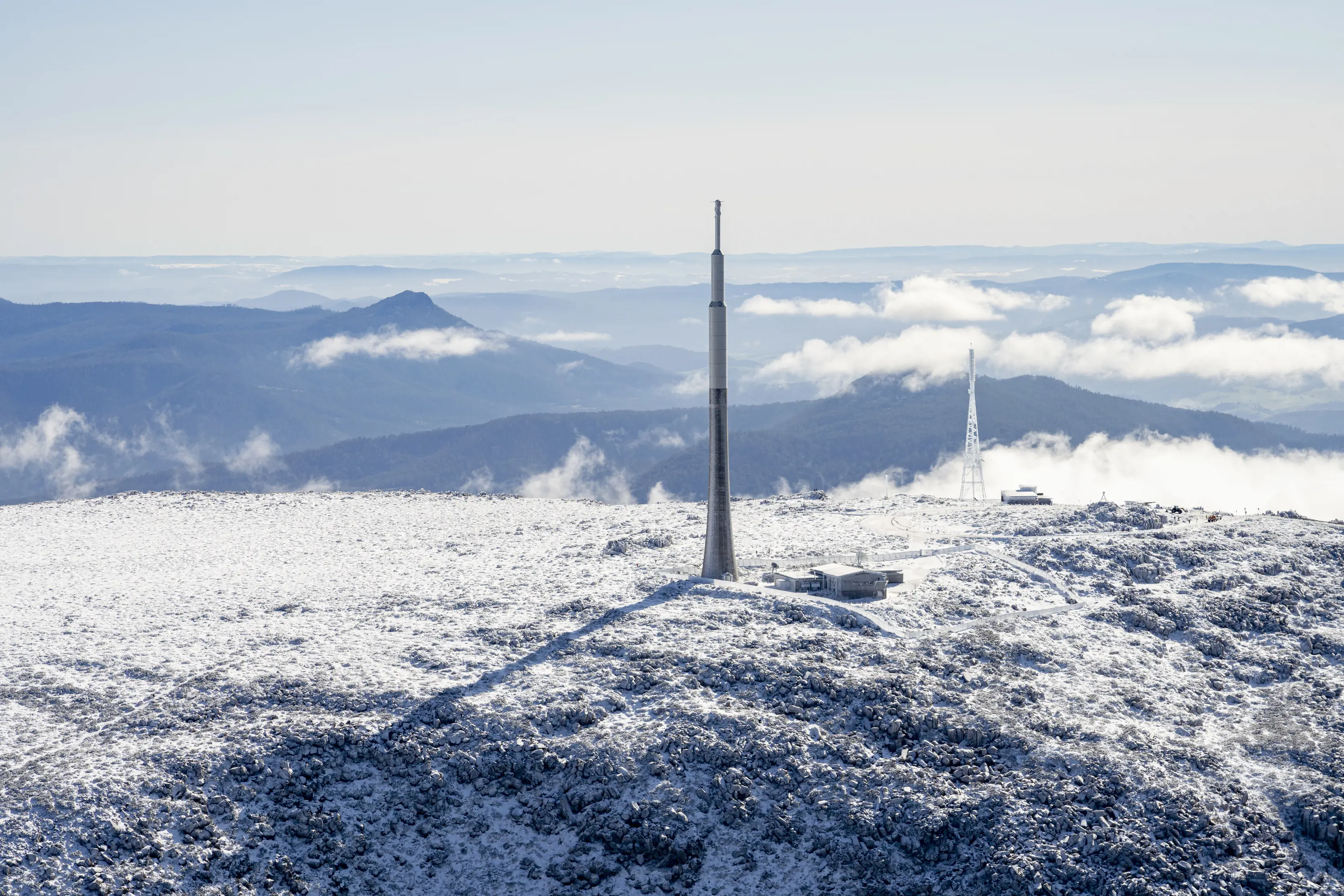 Aerials posted upon the Summit of Kunanyi / Mt Wellington, during a cool, winter's day, covered in snow and wispy clouds.