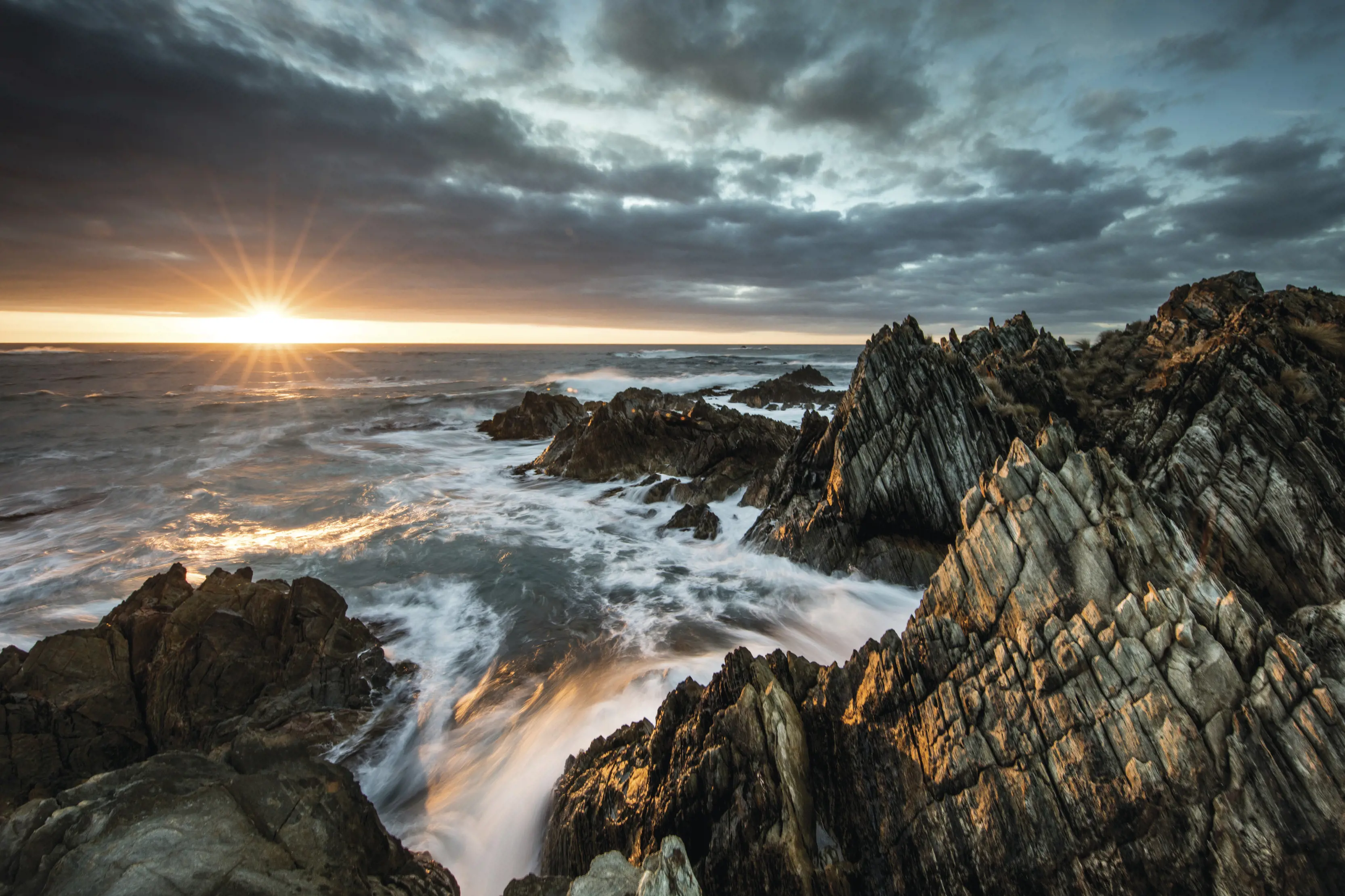 Incredible sunrise peeking over Gardiner Point, where the rocks meet the ocean.
