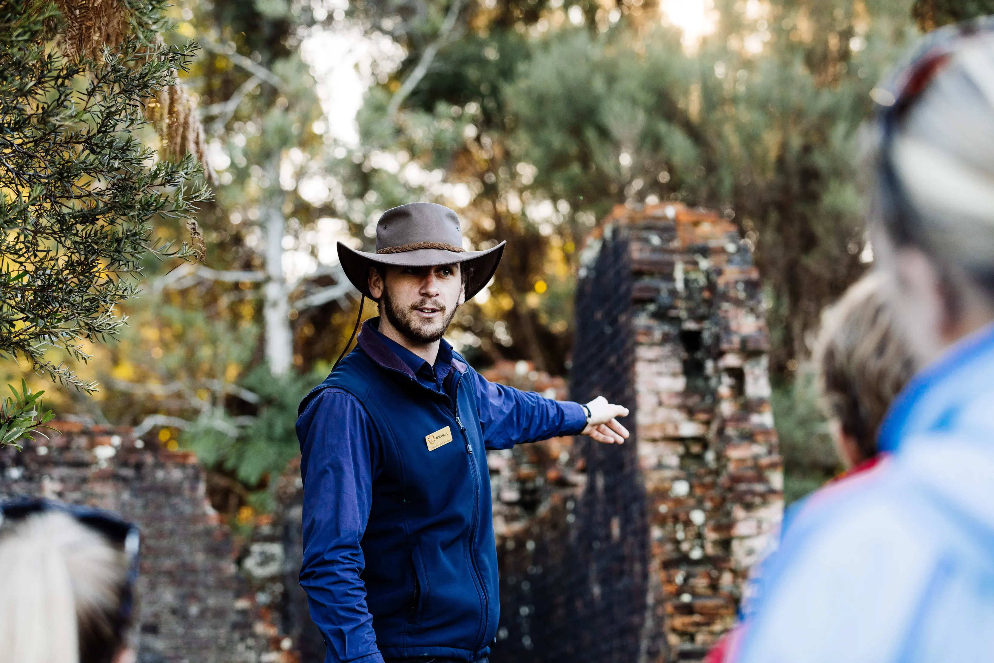 Tour guide, apart of Gordon River Cruises, pointing to a historic site to tourists on Sarah Island.