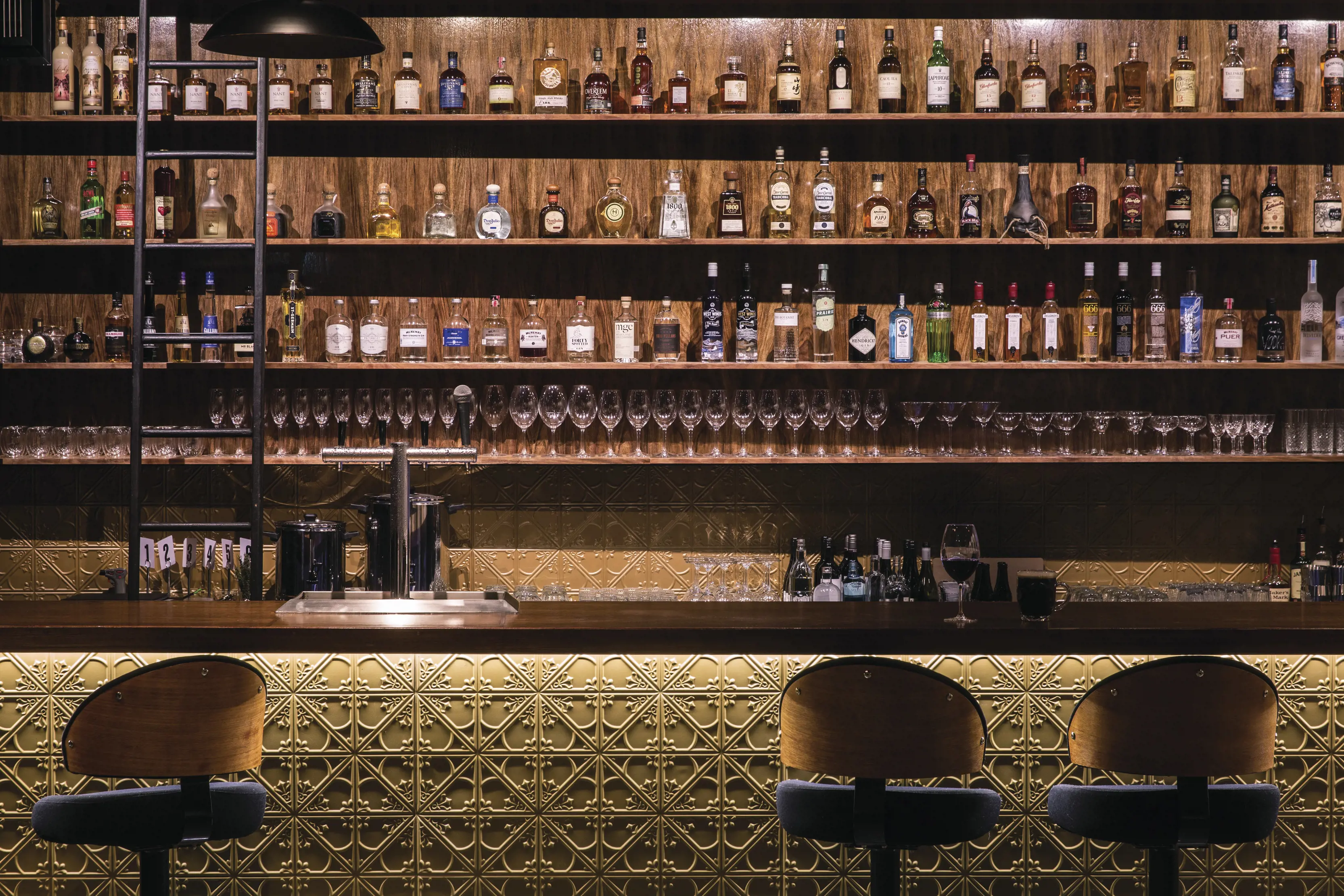 Charming, rustic image inside the Society Salamanca bar, showcasing fine cocktails, gin and whisky on the wall, located in Salamanca, Hobart.